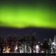 Očarljiv ples avrore borealis: nočno nebo zažarelo v zeleni barvi