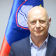 Postal minister za javno upravo in se po več letih spora nanadoma sodno poravnal s prejšnjim delodajalcem